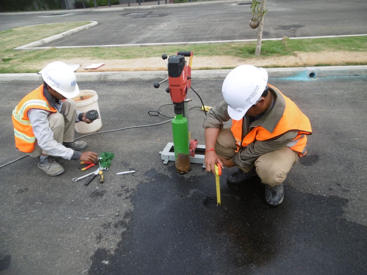 Coring asphalt pavement on site to check thickness