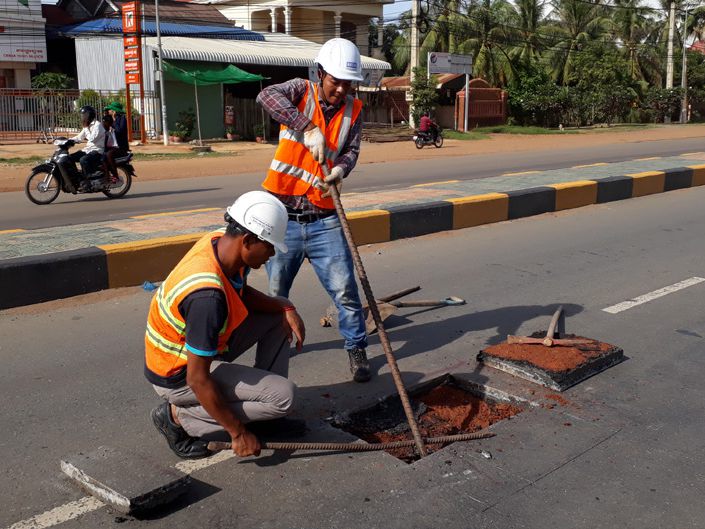 Technicians testing compacted road layers on site